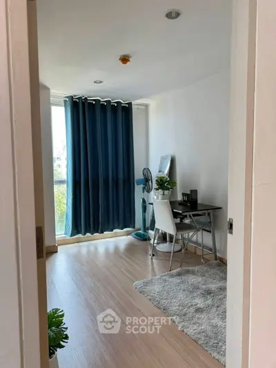 Modern study room with large window and stylish decor in a bright apartment.