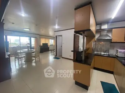 Spacious open-plan living and dining area with modern kitchen in a bright apartment.