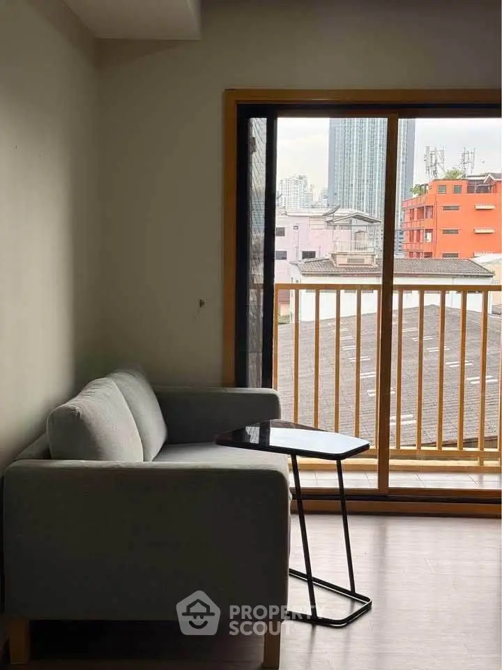 Cozy living room with a modern sofa and city view from the balcony.