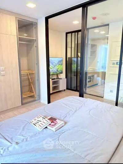 Modern bedroom with glass partition and stylish decor in a contemporary apartment.