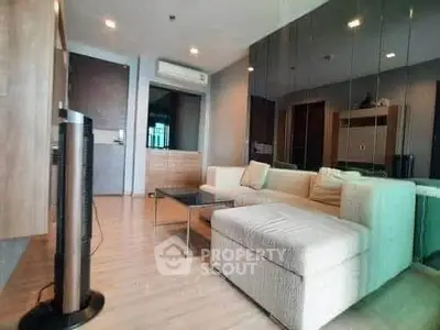 Modern living room with stylish furniture and mirrored wall in a cozy apartment.
