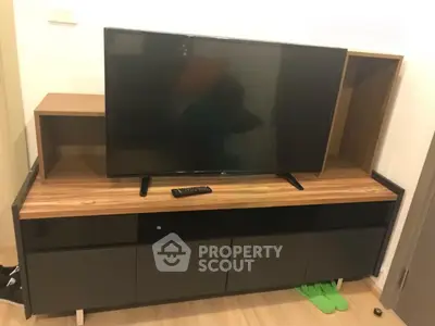 Modern living room with sleek TV stand and flat-screen television, perfect for entertainment setup.