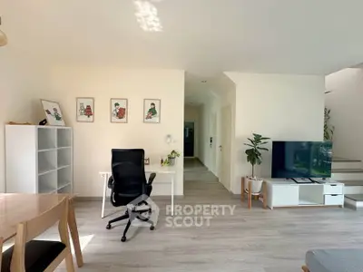 Modern living room with stylish decor, featuring a workspace and entertainment area, perfect for contemporary living.