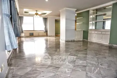 Spacious living room with marble flooring and built-in shelves in a modern apartment.