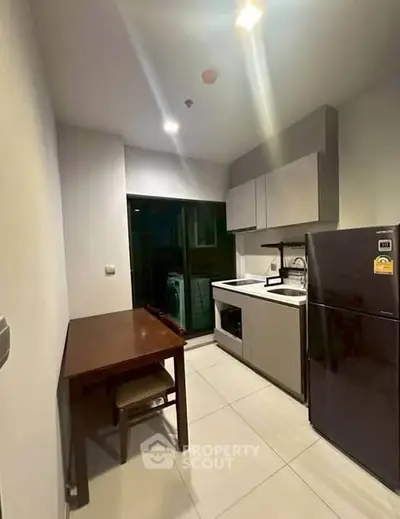 Modern kitchen with sleek cabinetry and appliances in a compact layout
