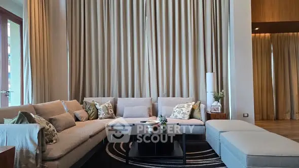 Luxurious living room with elegant decor and large windows, perfect for relaxation and entertaining.