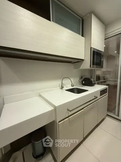 Modern kitchen with sleek white cabinetry and built-in appliances
