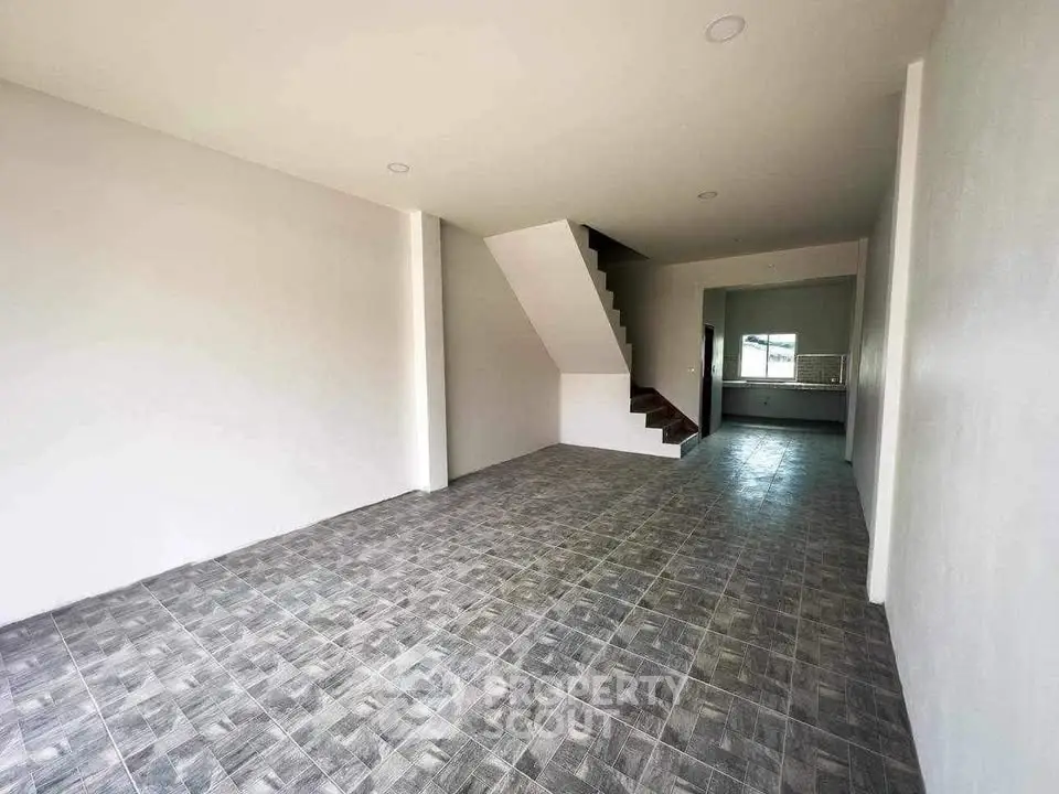 Spacious open-plan living area with modern tiled flooring and staircase