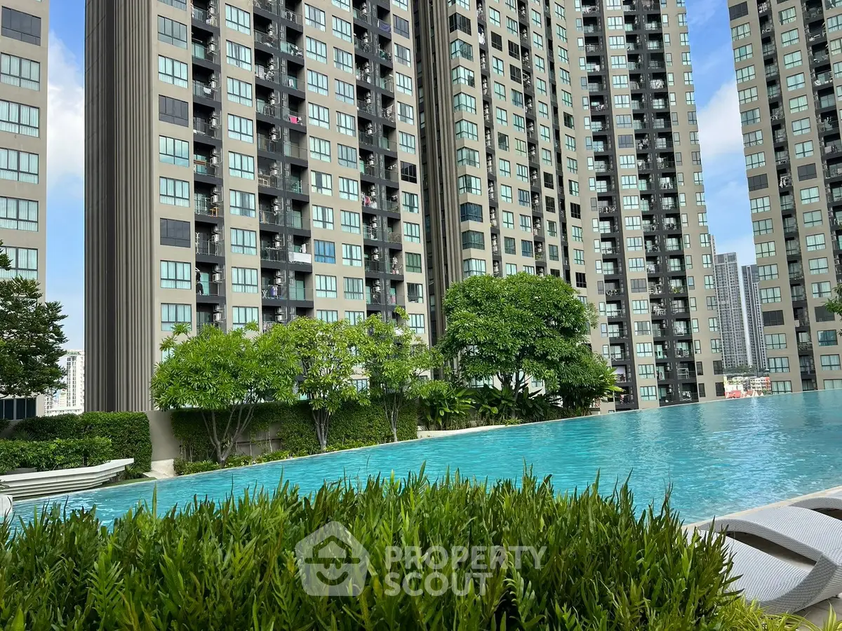 Luxurious high-rise apartment complex with stunning pool and lush greenery, perfect for urban living.