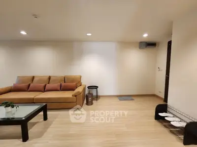 Spacious living room with modern sofa and coffee table, ideal for relaxation.