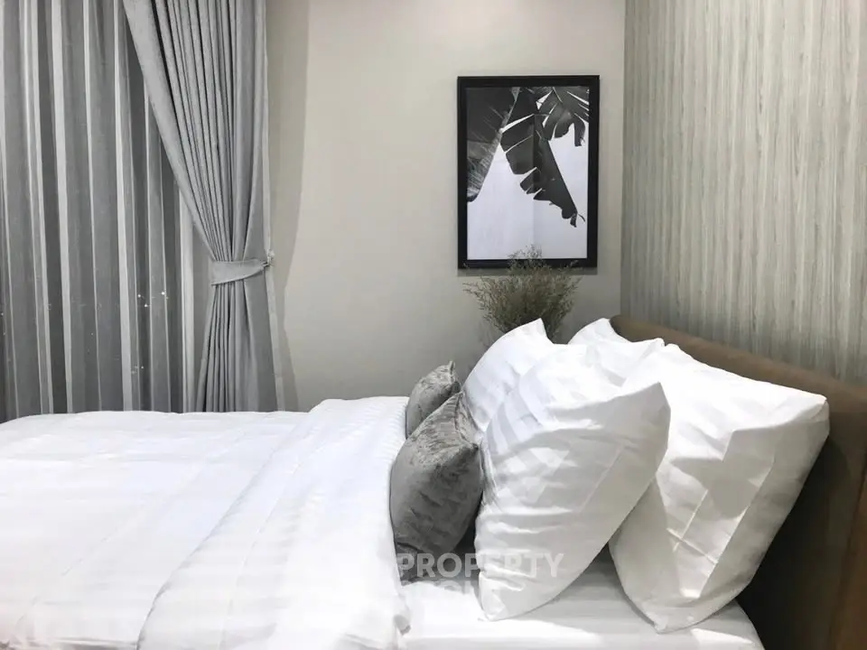 Modern bedroom with elegant decor and cozy bedding in a stylish apartment.