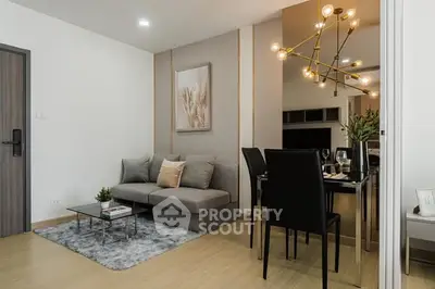 Modern living room with stylish decor and dining area, featuring elegant lighting and cozy seating.