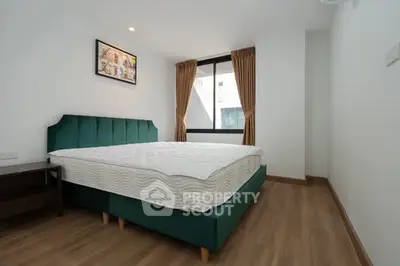 Modern bedroom with stylish bed and large window, perfect for cozy living.