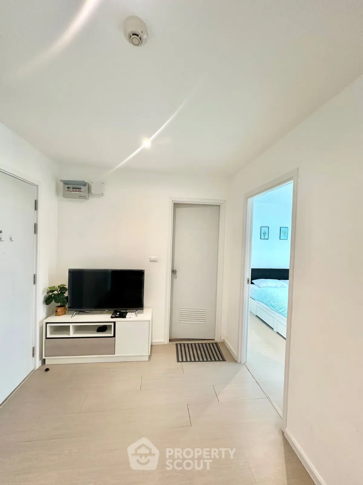 Modern apartment interior with sleek TV setup and cozy bedroom view