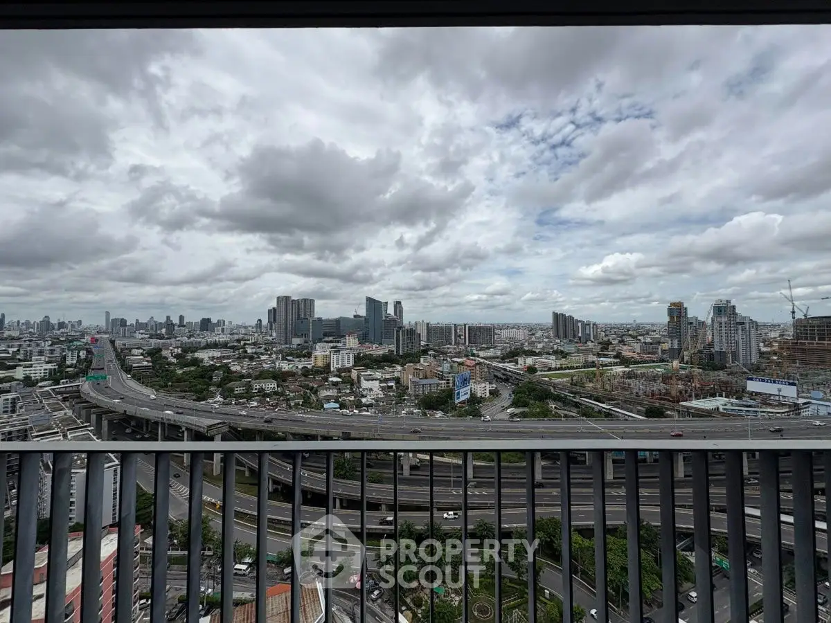 Stunning cityscape view from a high-rise balcony overlooking urban skyline and highway.