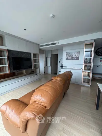 Spacious modern living room with leather sofa and built-in entertainment center