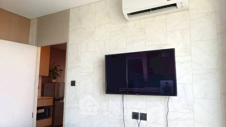 Modern living room with wall-mounted TV and air conditioning unit, featuring sleek marble wall design.