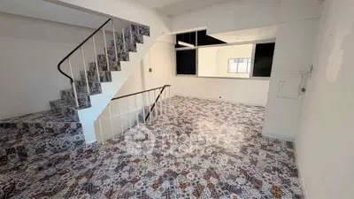 Spacious interior with unique patterned tile flooring and staircase, ideal for modern living.