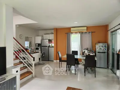 Spacious open-plan living and dining area with modern kitchen appliances.