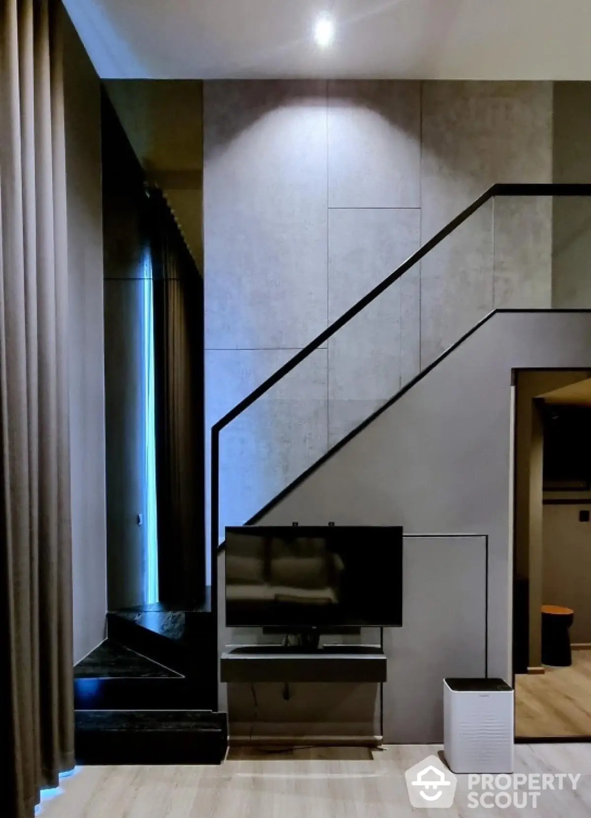 Modern living room with sleek staircase and TV setup