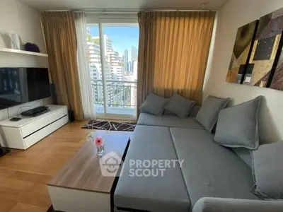 Modern living room with large sofa and city view balcony in high-rise apartment