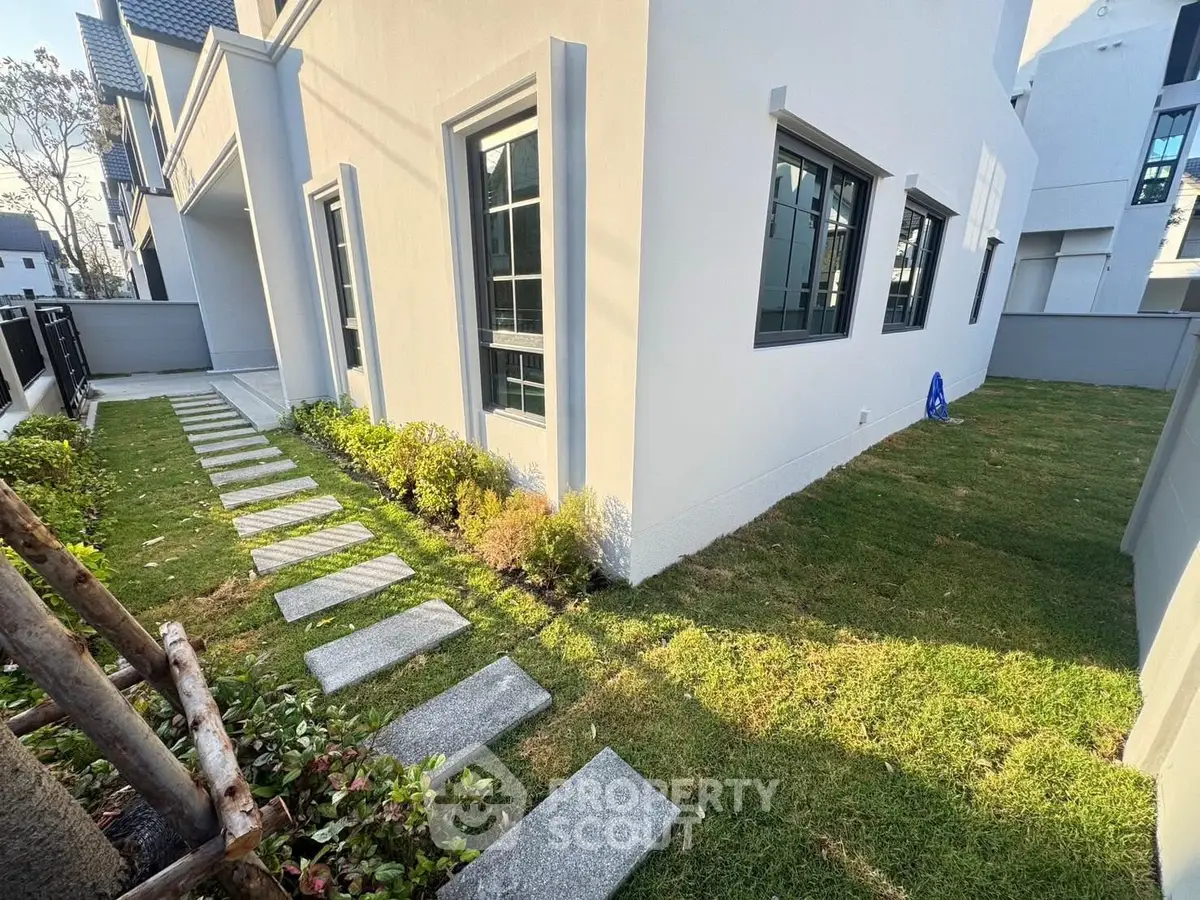 Modern house exterior with lush green lawn and pathway