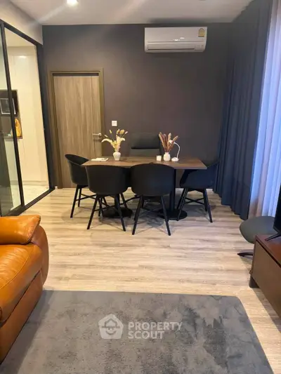 Modern living room with stylish dining area and sleek air conditioning unit.