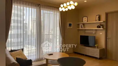 Modern living room with large windows and stylish decor in a high-rise apartment.