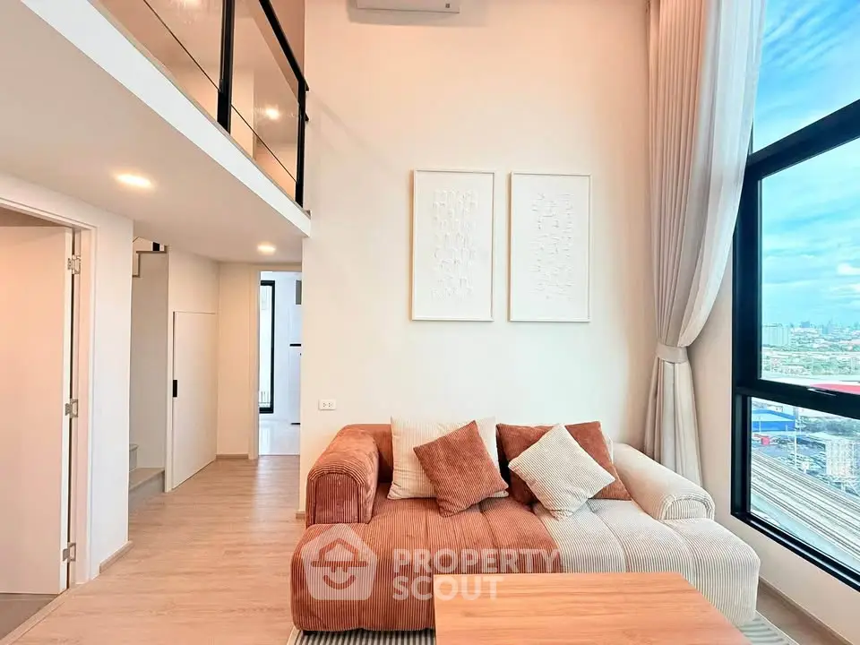 Modern loft apartment with high ceilings and large windows offering stunning city views.