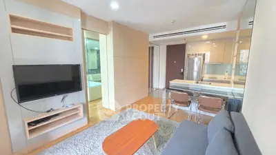 Modern living room with open kitchen and sleek furniture in a cozy apartment.