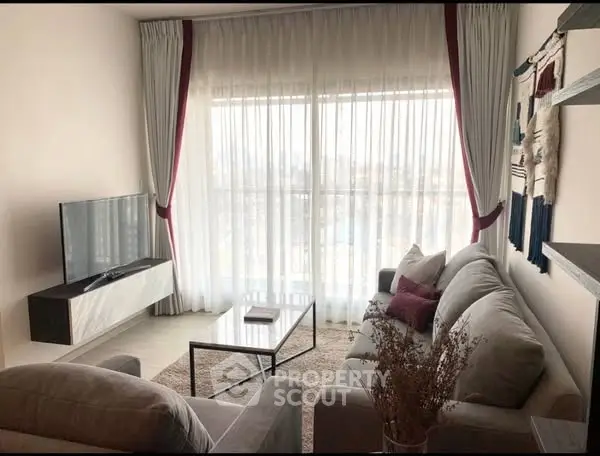 Stylish living room with modern decor and large window view.