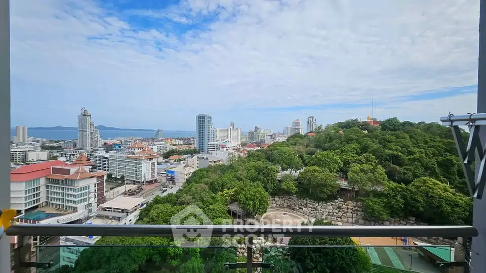 Stunning cityscape view from a high-rise balcony overlooking lush greenery and urban skyline.
