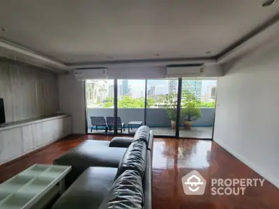 Spacious living room with city view and large balcony access.