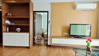 Modern living room with wooden flooring, built-in shelves, and air conditioning.