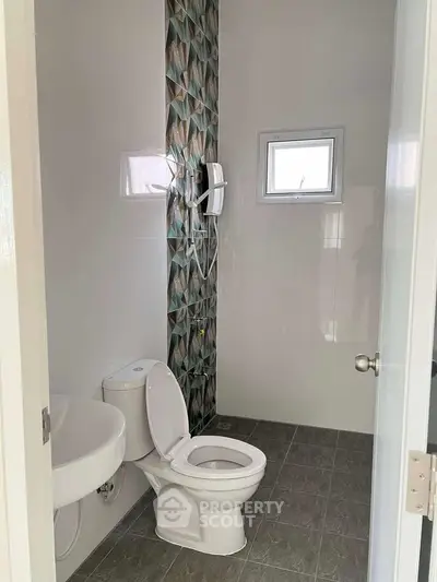 Modern bathroom with stylish tile accent and compact design