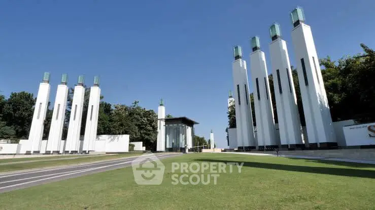 Stunning architectural exterior with modern pillars and lush green surroundings.