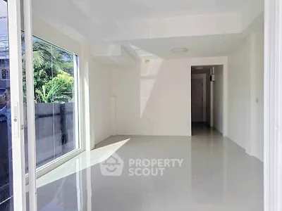 Bright and spacious empty room with large window and glossy floor tiles, perfect for customization.