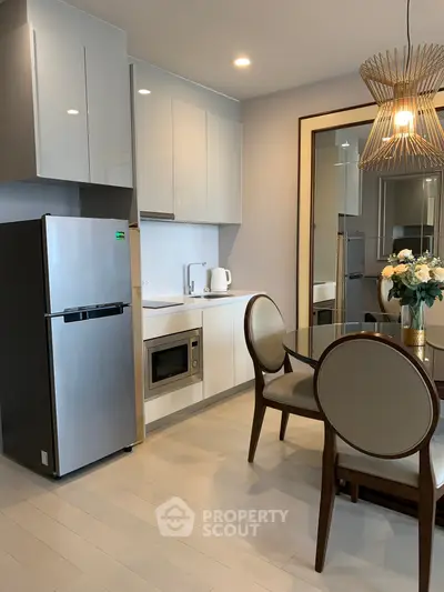 Modern kitchen with sleek appliances and elegant dining area in a stylish apartment.