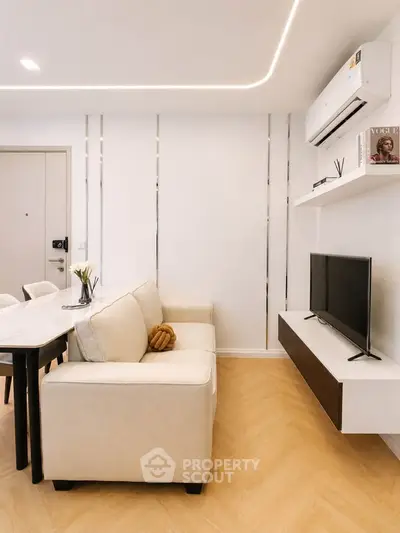 Modern living room with sleek design, featuring a cozy sofa, wall-mounted TV, and elegant dining area.