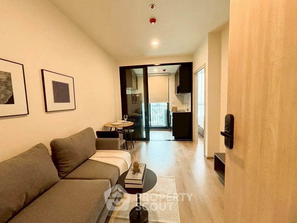 Modern living room with cozy sofa and open kitchen layout, perfect for urban living.