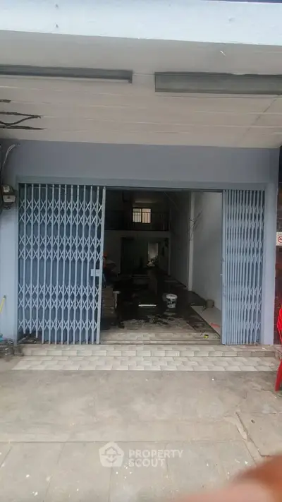 Spacious commercial property with open layout and secure metal gate, ideal for business setup.