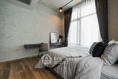 Modern bedroom with stylish decor and large window offering natural light.