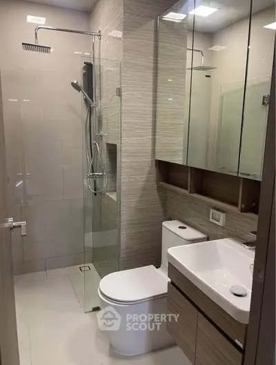 Modern bathroom with glass shower and sleek fixtures in a contemporary apartment.