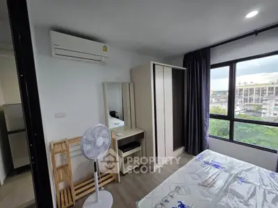 Modern bedroom with large window and air conditioning in urban apartment