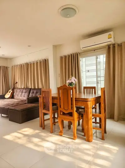 Spacious living room with elegant dining set and cozy sofa, featuring abundant natural light and modern air conditioning.