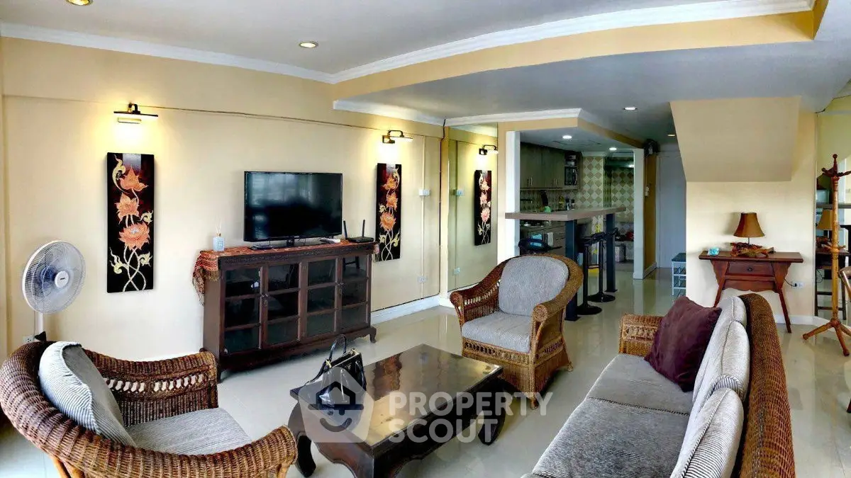 Spacious living room with elegant wicker furniture and modern decor, perfect for relaxation and entertainment.