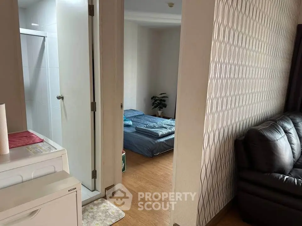 Cozy apartment interior with bedroom and living area, featuring modern decor and wooden flooring.