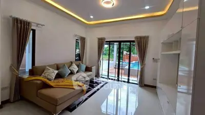 Spacious living room with modern decor and pool view, perfect for relaxation and entertainment.