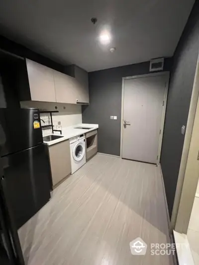 Modern compact kitchen with washing machine and sleek cabinetry