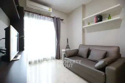 Modern living room with sleek sofa, wall-mounted shelves, and natural light from large window.